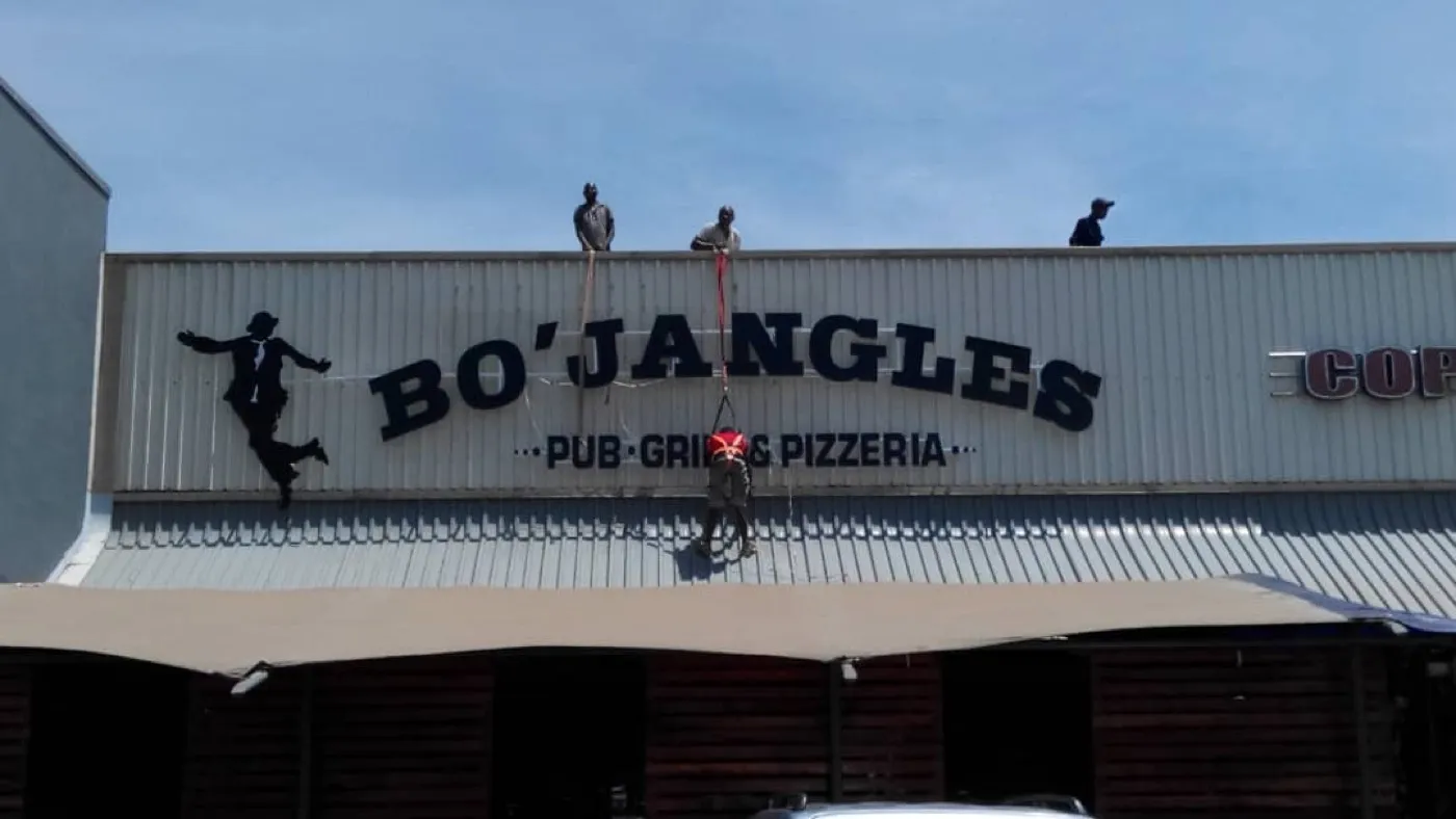 Elev8 crew installing Bo’Jangles 3D letters on a roofline