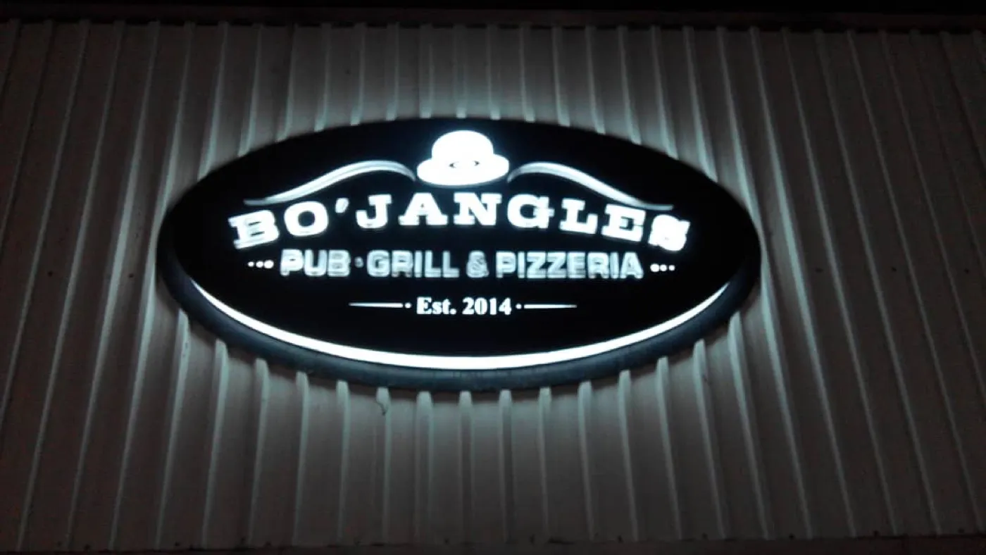 Backlit oval Bo’Jangles Pub, Grill & Pizzeria logo sign at night