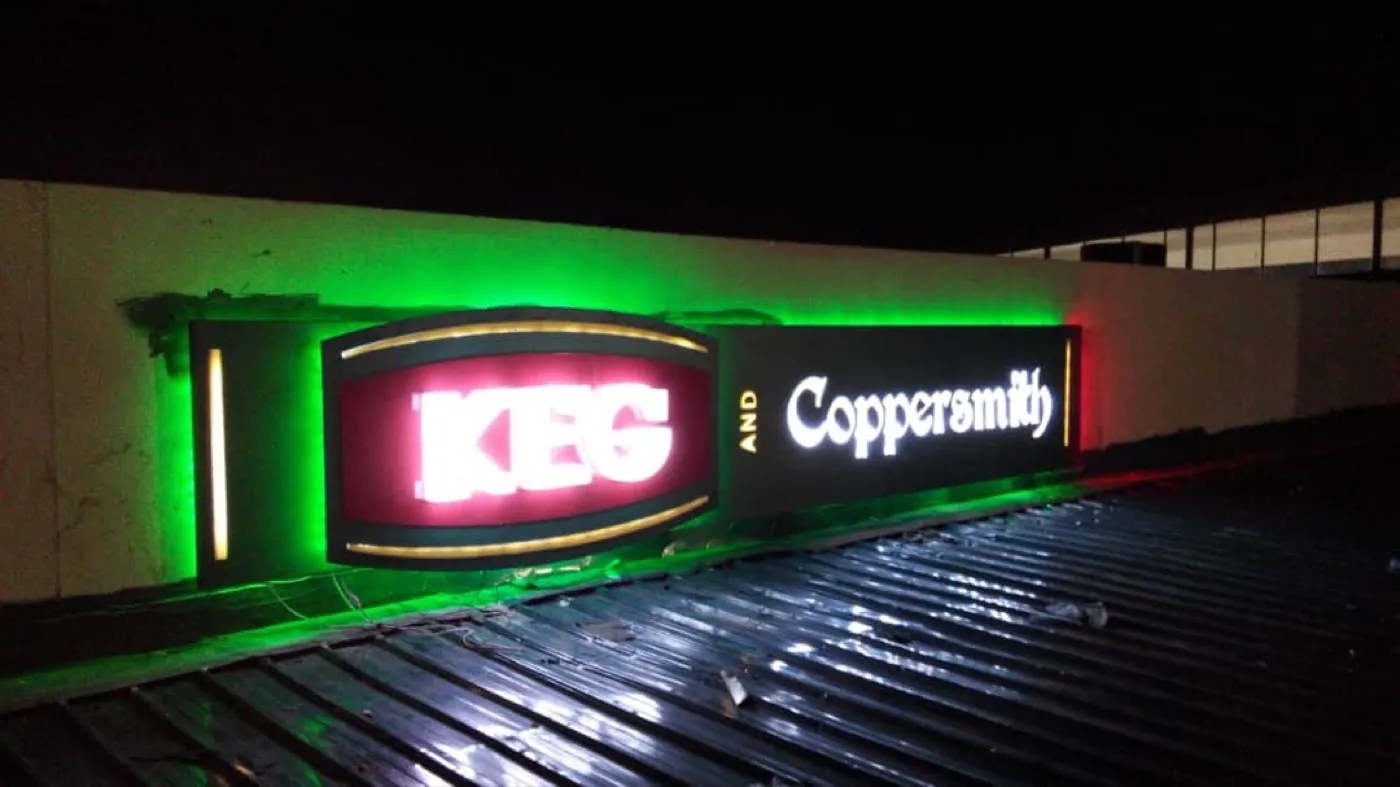 Illuminated KEG and Coppersmith signage at night